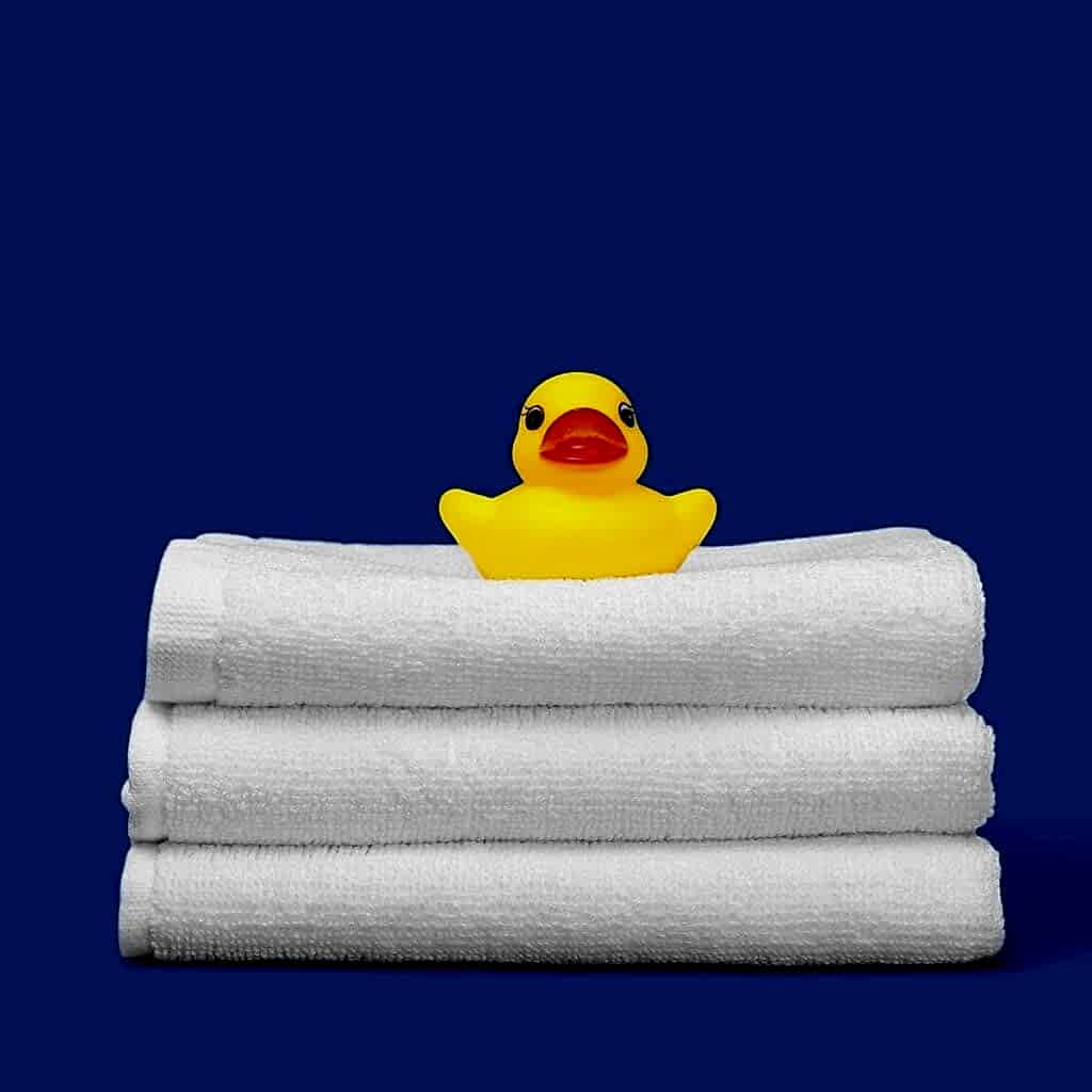 Çeyizlique beyaz havlular ve banyo ördeği vektör